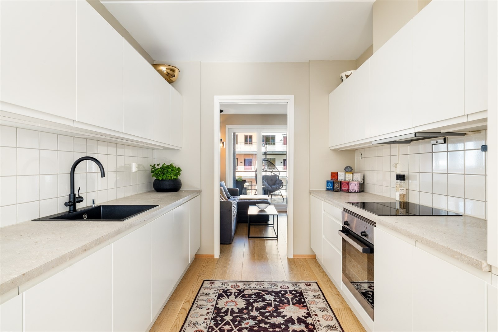 Kjøkkenet er lyst og trivelig og har integrerte hvitevarer og mye benkeplass Galleribilde