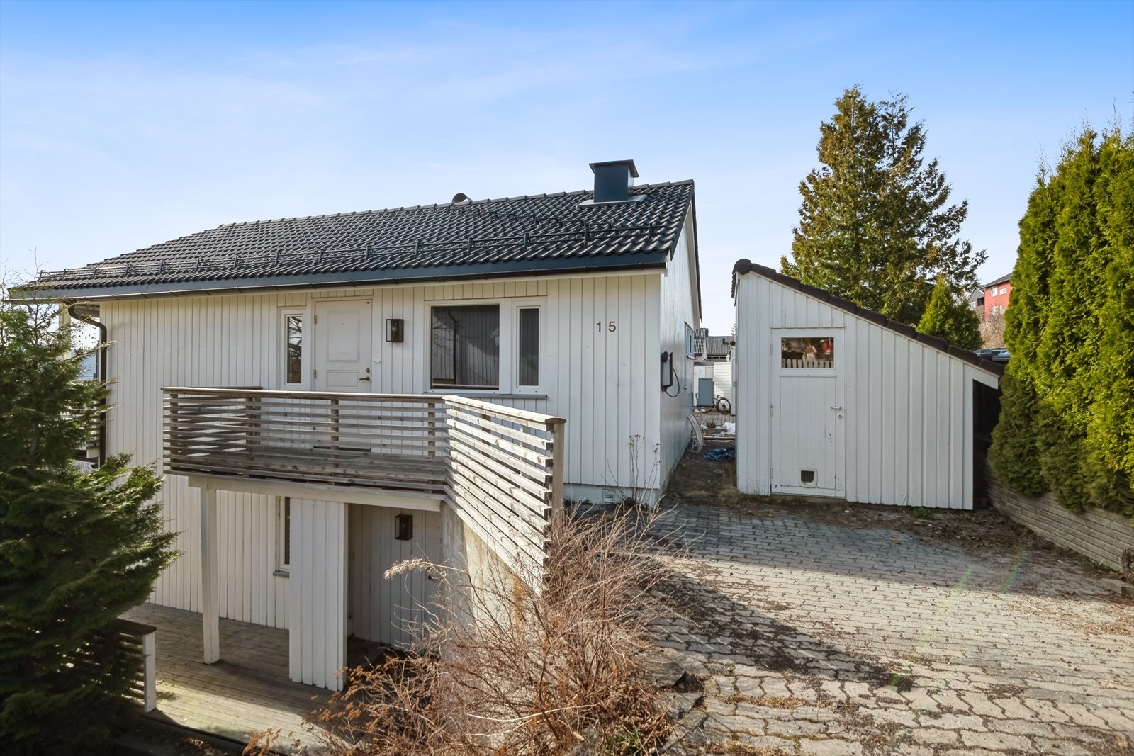 Gårdsplass med el-bil lader, sportsbod og inngangsparti til 1. etasje. Galleribilde