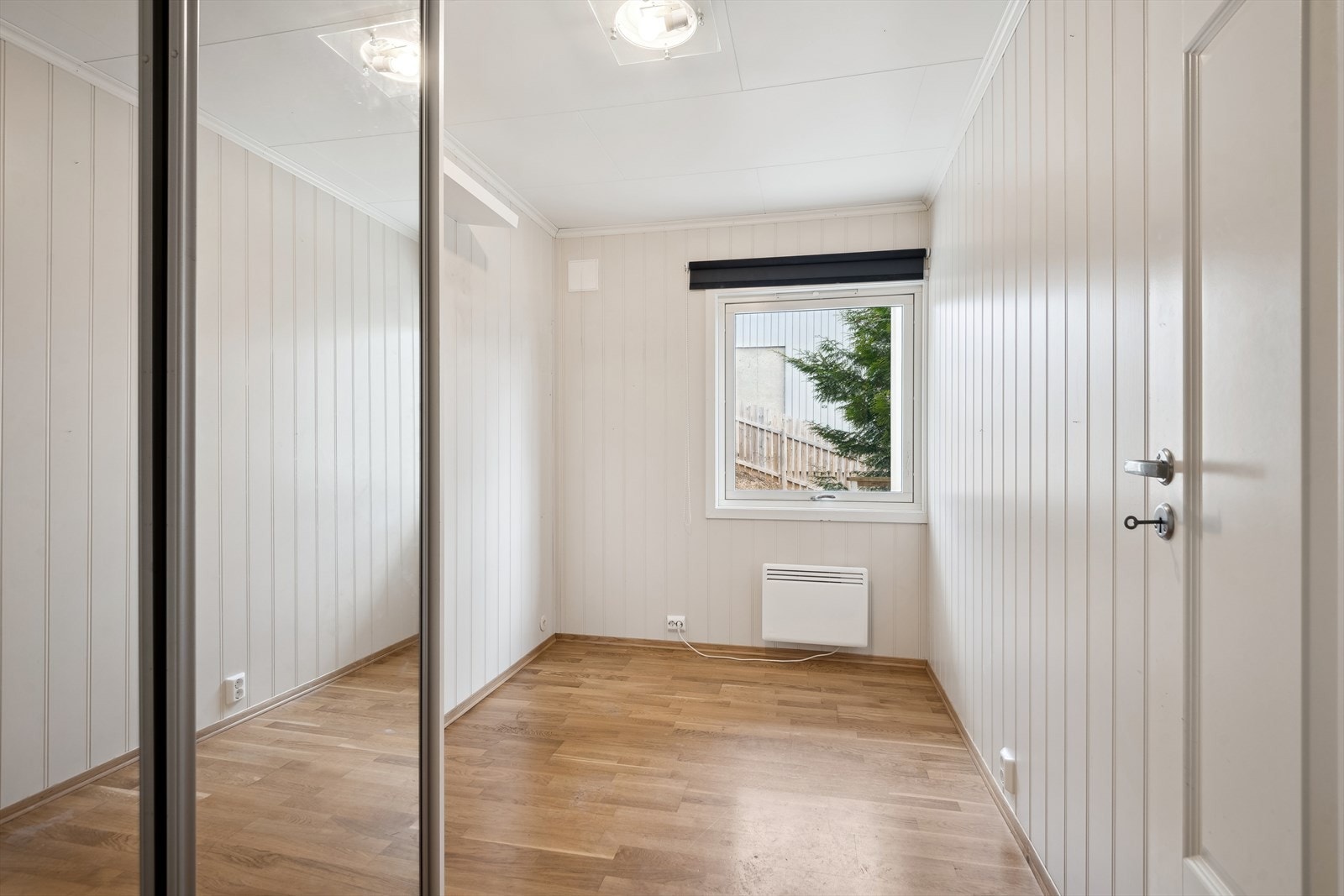 Lite, men smart soverom med skyvedørsgarderobe og speil. Galleribilde