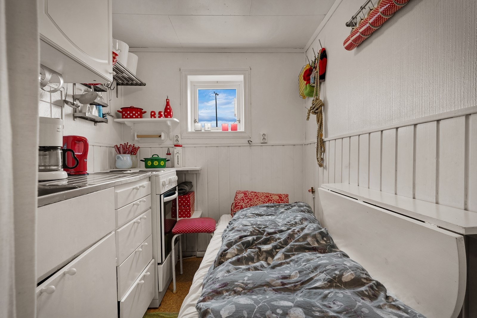 Kjøkken utført med profilerte fronter på overskap, og slette fronter på underskap. Det er montert et praktisk spisebord på veggen som enkelt kan slås ned om man trenger gulvplass. Galleribilde