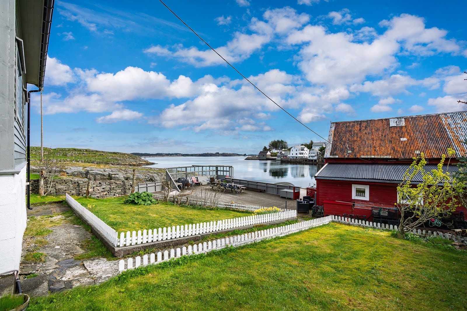 Like nedenfor fritidsboligen ligger eiendommens naust og terrasse. Galleribilde