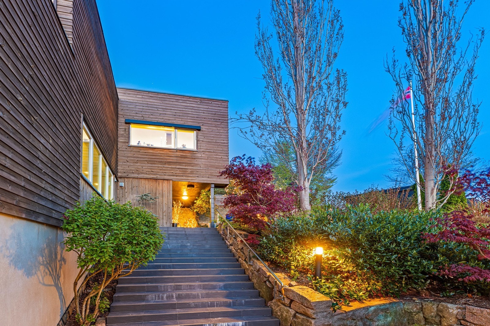 Innbydende inngangsparti med flotte beplantninger og utebelysning Galleribilde