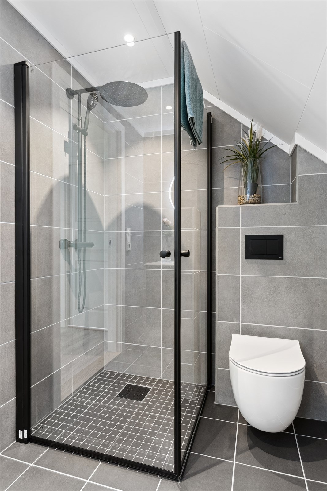 Det er vegghengt toalett og dusj med nedsenket dusjsone og innfellbare dører. Galleribilde