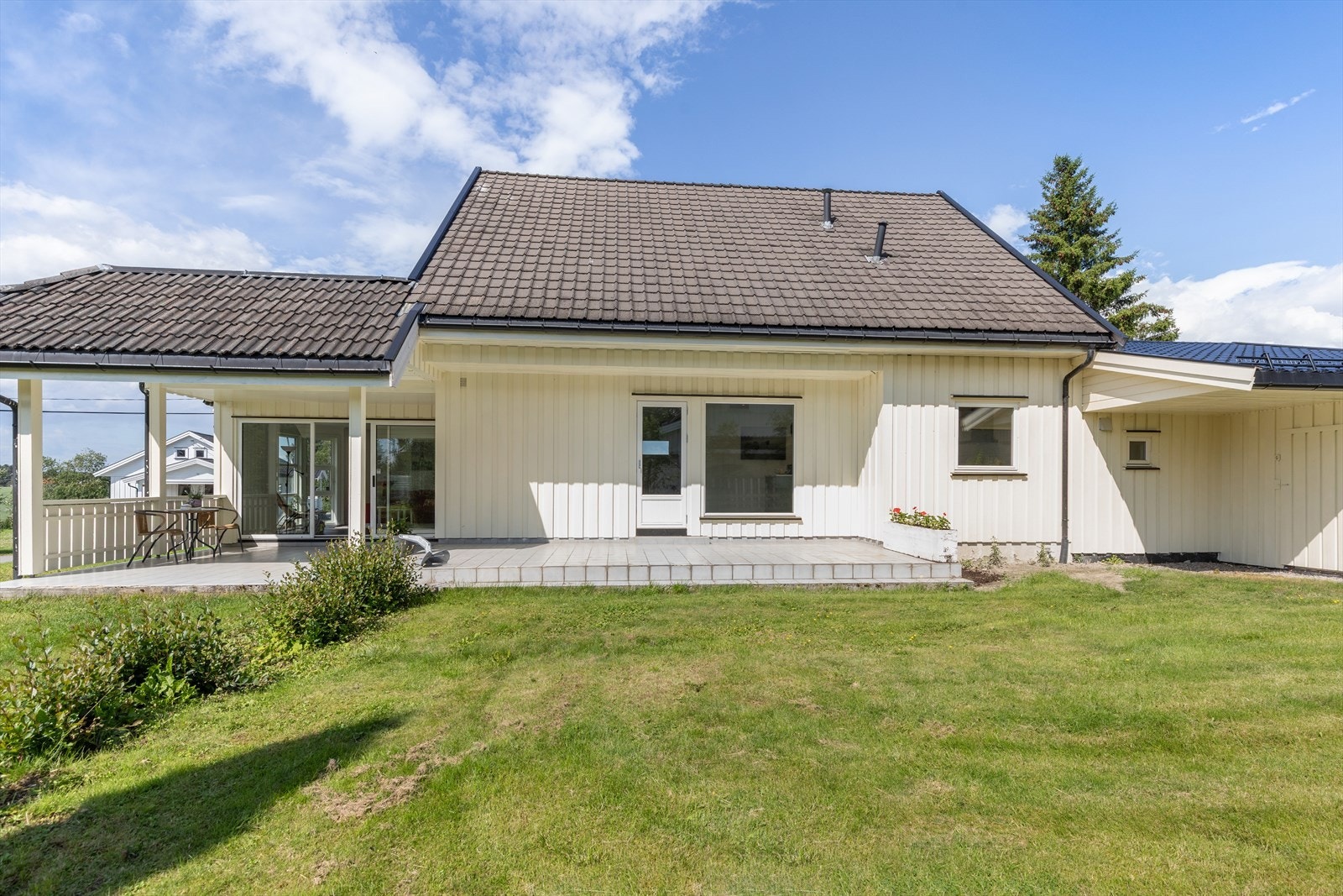 Boligen har en flat tomt som er opparbeidet med plen og diverse beplantning. Galleribilde