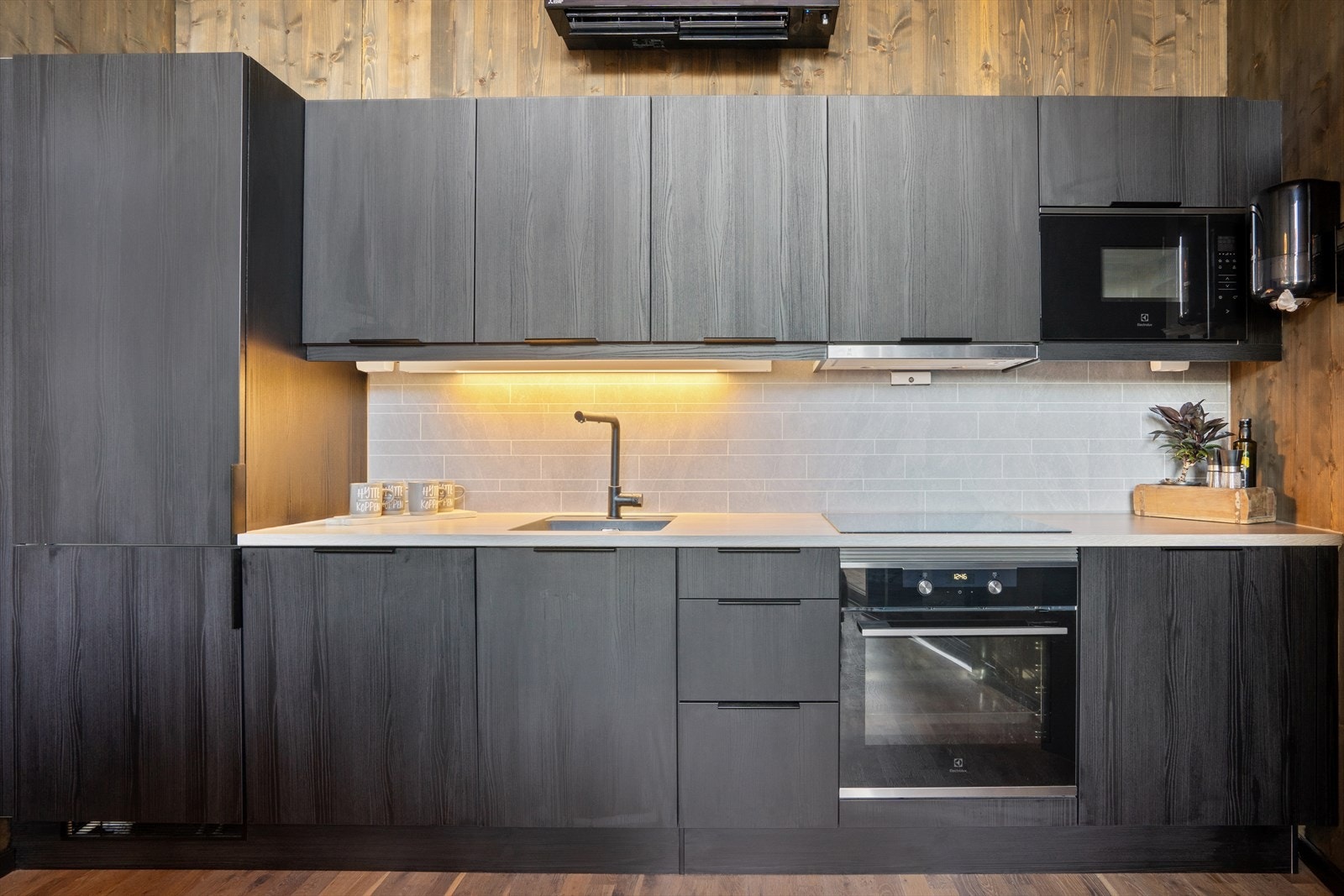 Kjøkkenet er innredet med integrerte hvitevarer som keramisk koketopp, stekeovn, mikro, kjøleskap med fryser og oppvaskmaskin. Galleribilde