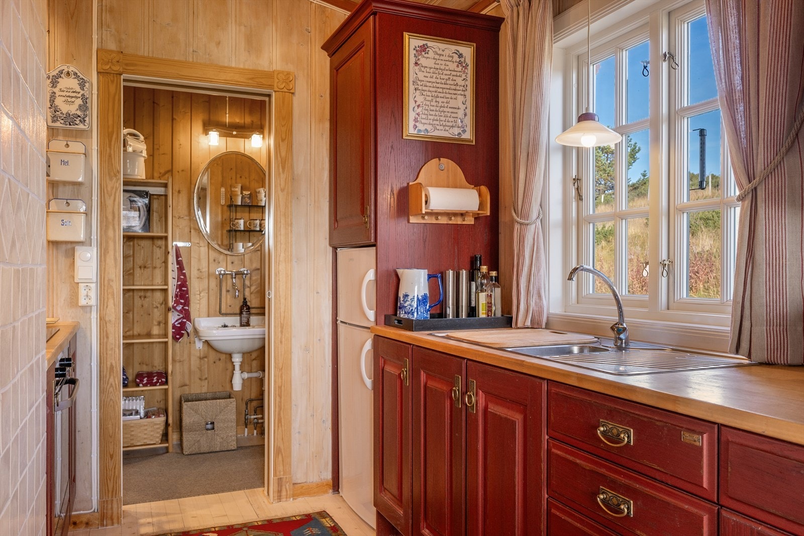 Innenfor kjøkkenet er det rom innredet med servant og speil. I tillegg lagringsplass. Galleribilde