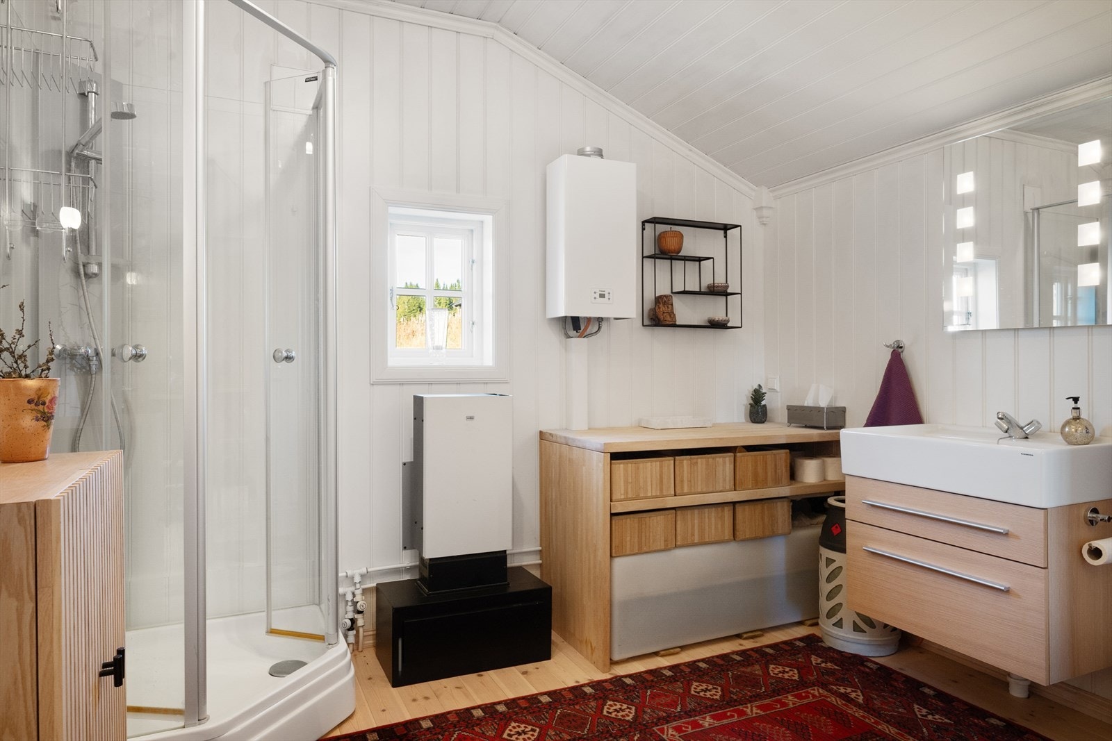 Hytta har et romslig sanitærrom med panelte vegger og tregulv. Galleribilde