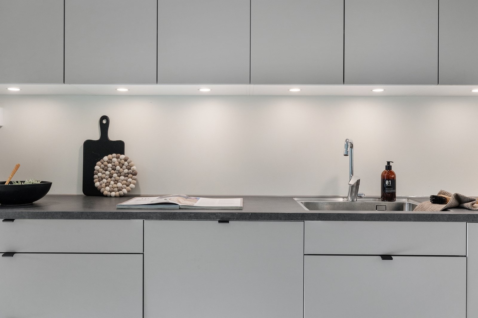 Her er alle hvitevarer integrert og kjøkkenet byr på mye skap- og benkeplass. Galleribilde