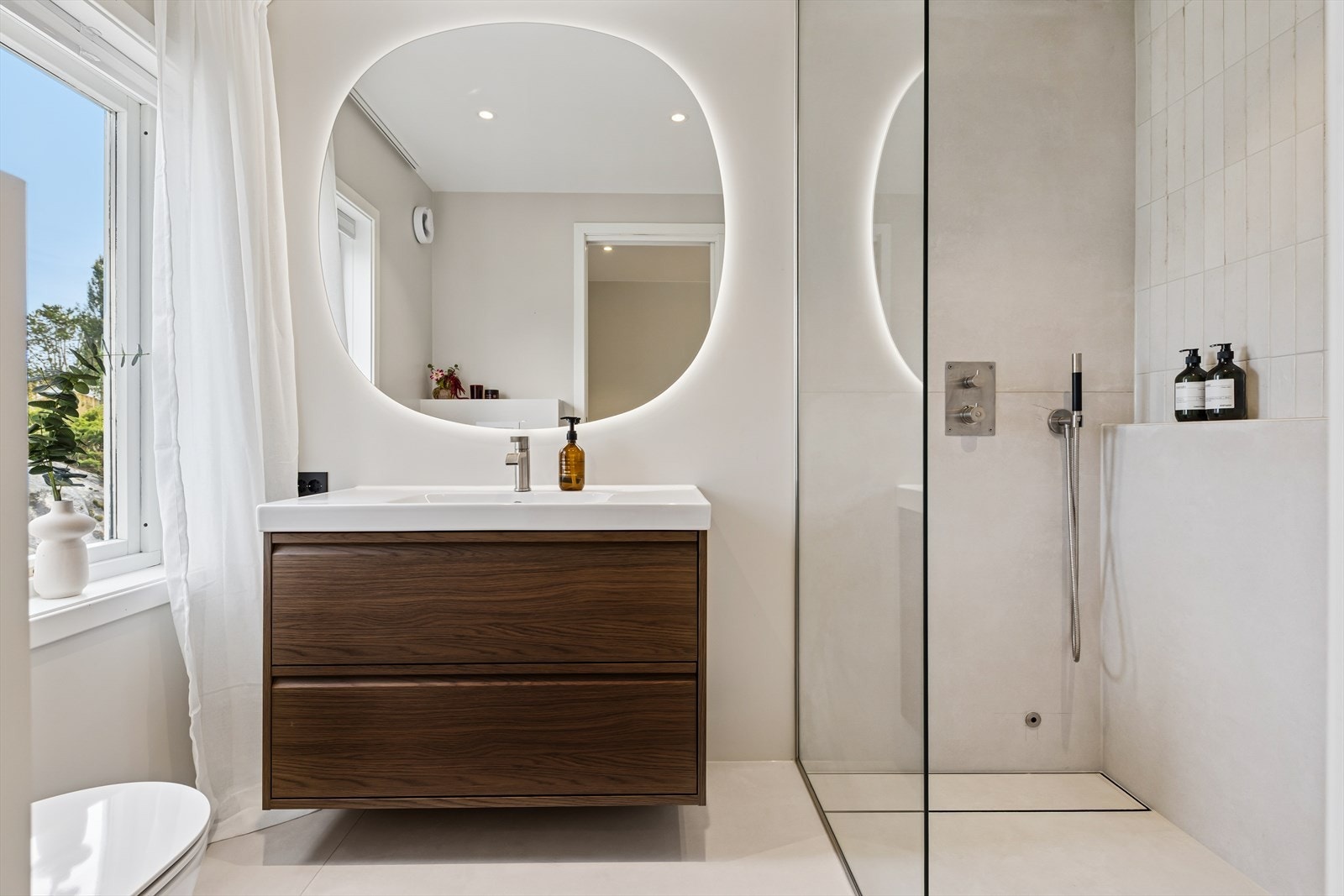 Det andre badet er innredet i tilsvarende stil, men er noe mindre og utstyrt med dusjhjørne, vegghengt toalett og baderomsinnredning med nedfelt servant. Galleribilde