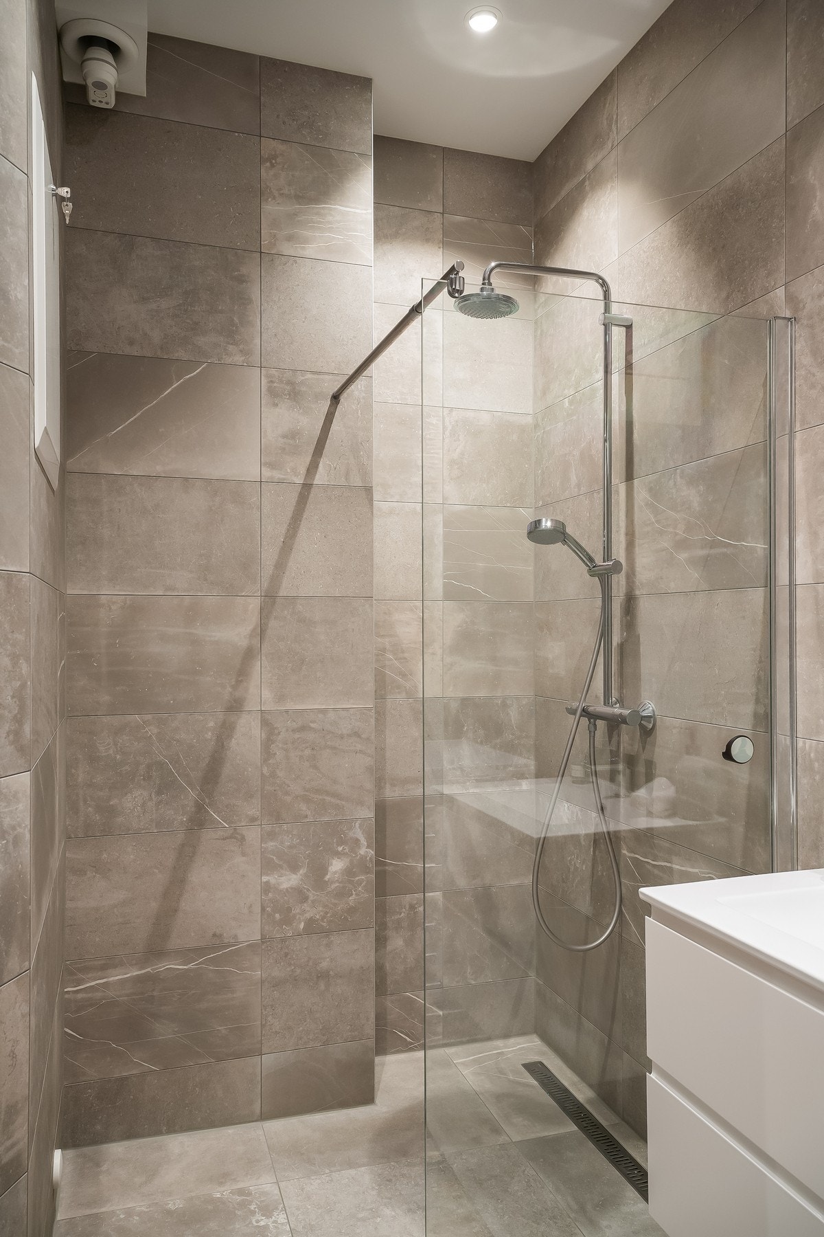 Badet er pusset opp i 2020 og holder høy standard med flislagte gulv og vegger, gulvvarme, dusjhjørne med glassvegger, servantskap med servant og vegghengt toalett. Galleribilde