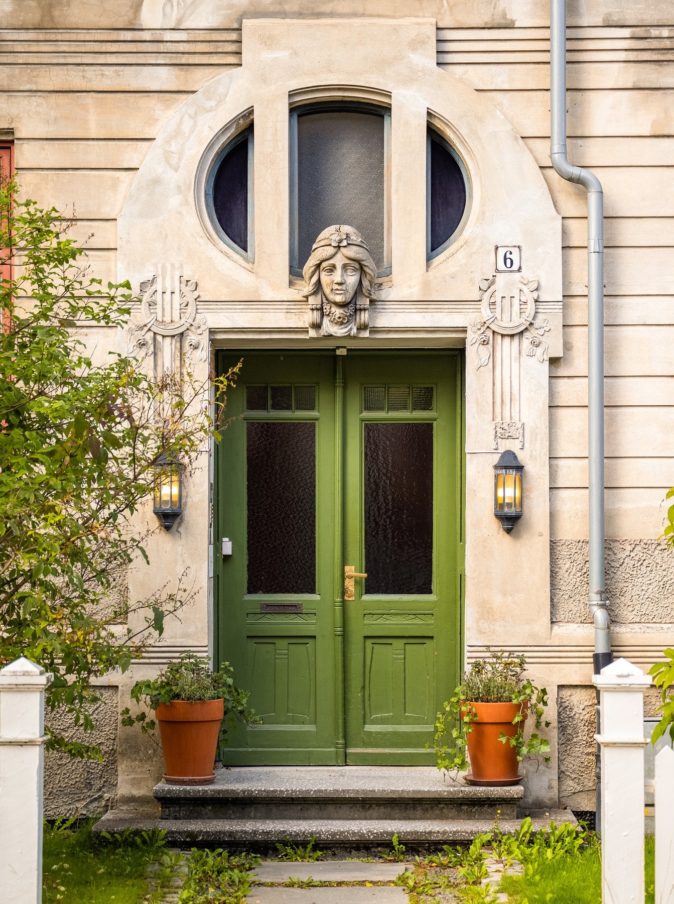 Klassisk dobbeltdør med steintrapp og dekorative detaljer på fasaden, som tar deg inn i bygget. Galleribilde