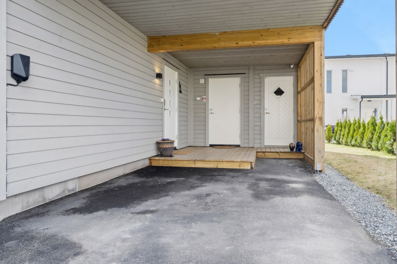 Overbygd inngangsparti med platting og adkomst til to utvendige boder. Den ene boden er isolert Galleribilde