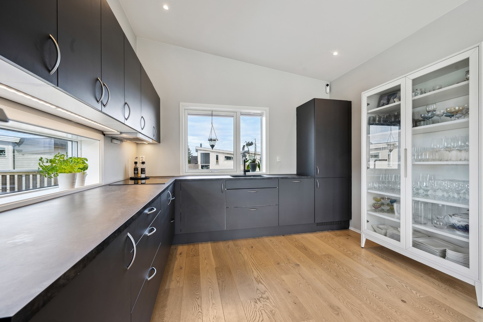 Integrerte hvitevarer består av oppvaskmaskin, stekeovn, induksjonstopp, mikrobølgeovn og kjøleskap med fryserdel Galleribilde