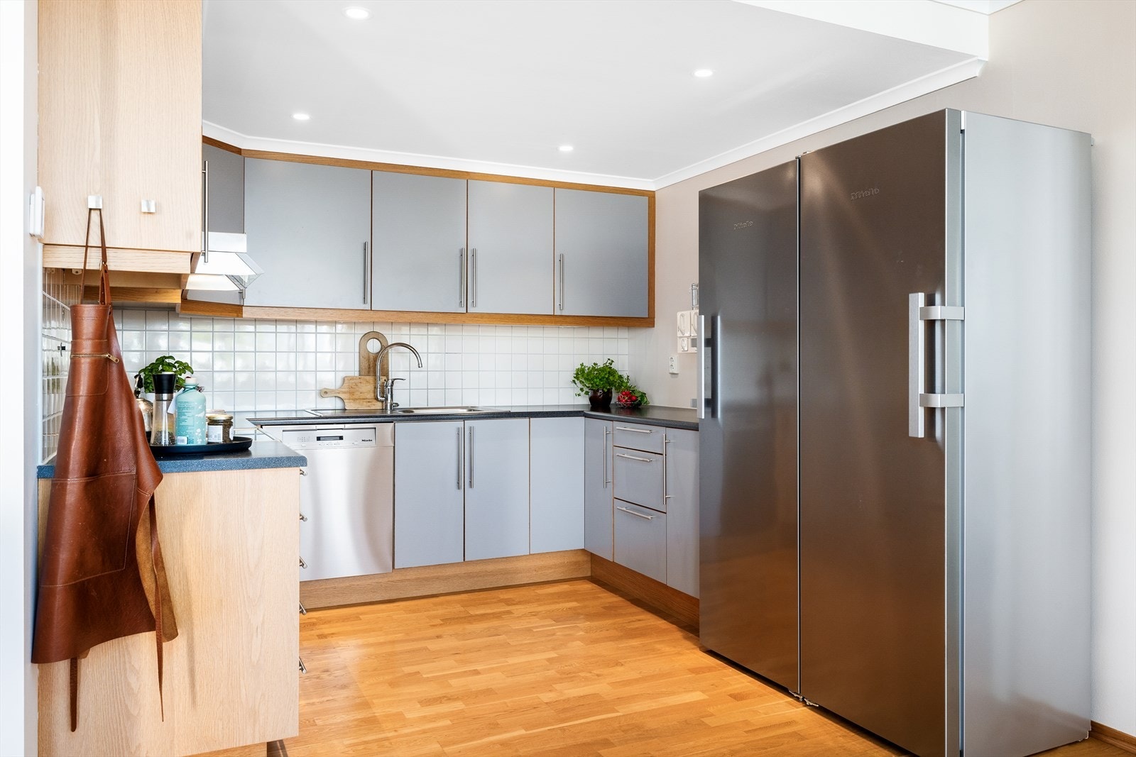 Benkeplaten er i slitesterk laminat med nedfelt oppvaskkum, og det er flislagt mellom benk og overskap - både praktisk og dekorativt. Galleribilde