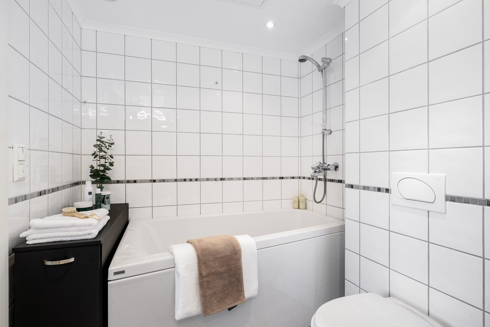 Det flislagte badet/vaskerommet har en praktisk og moderne utforming med direkte adkomst fra hovedsoverommet - en løsning som gir både komfort og funksjonalitet i hverdagen. Galleribilde