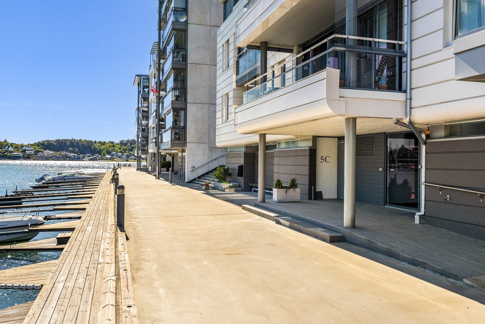 Rett utenfor døren finner du trivelige uteområder som innbyr til både ro og aktivitet. En kort spasertur tar deg ned til bryggekanten, hvor du kan nyte sjøluften, rusle langs vannet eller slå deg ned på en benk og følge med på båtlivet. Galleribilde