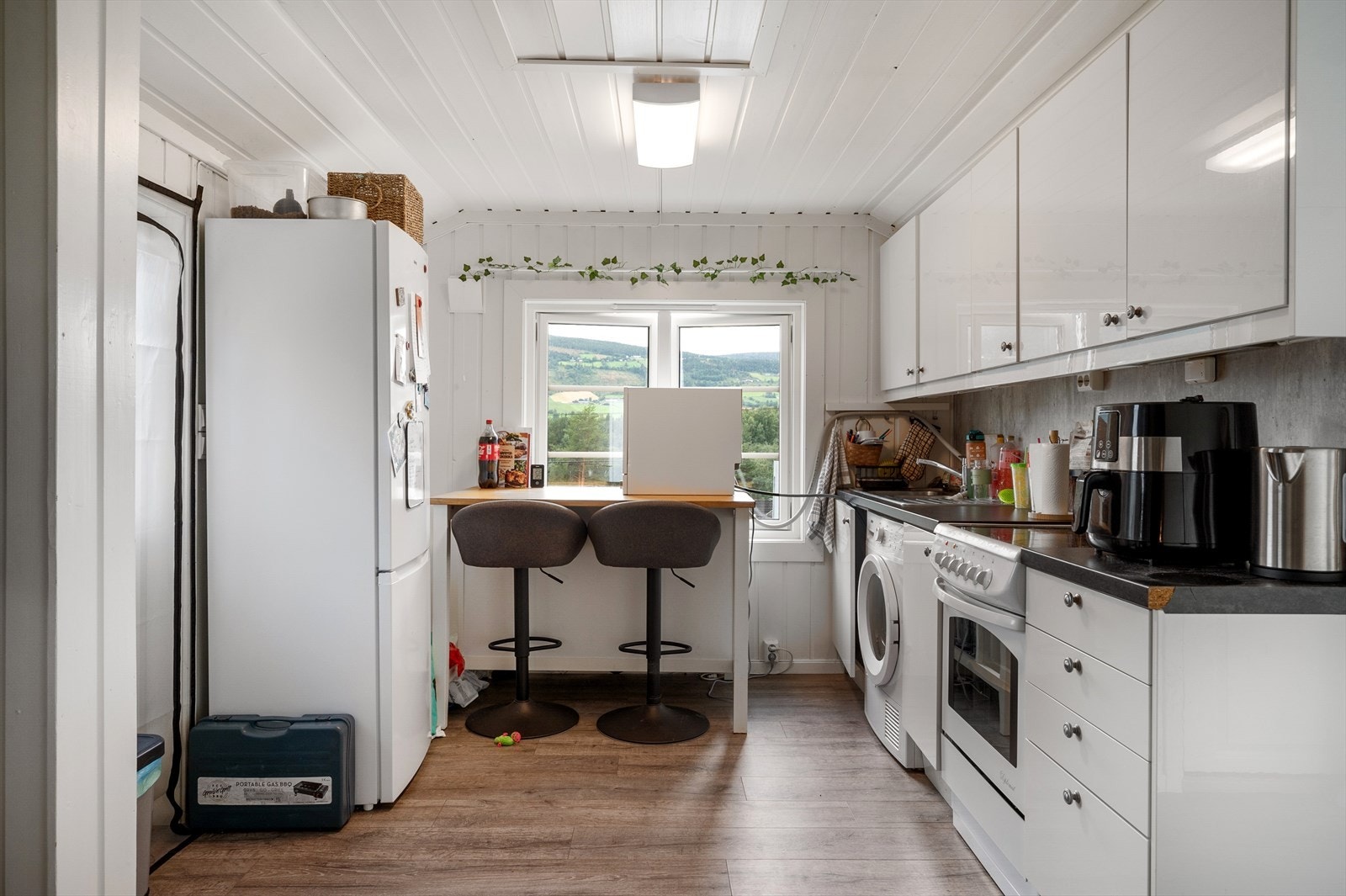 Kjøkkeninnredning med frittstående hvitevarer. Galleribilde