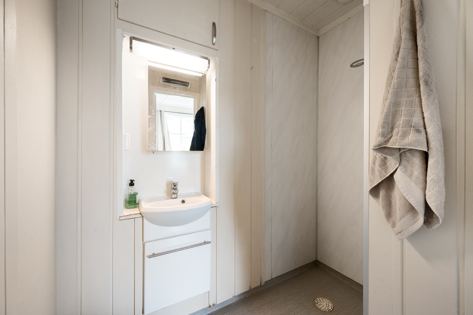 Enkelt bad med servant i innredning og dusjnisje. Galleribilde