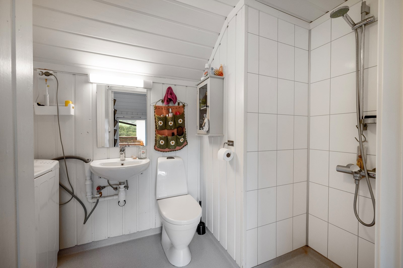 Bad med opplegg for vaskemaskin, servant, toalett og dusjnisje. Galleribilde