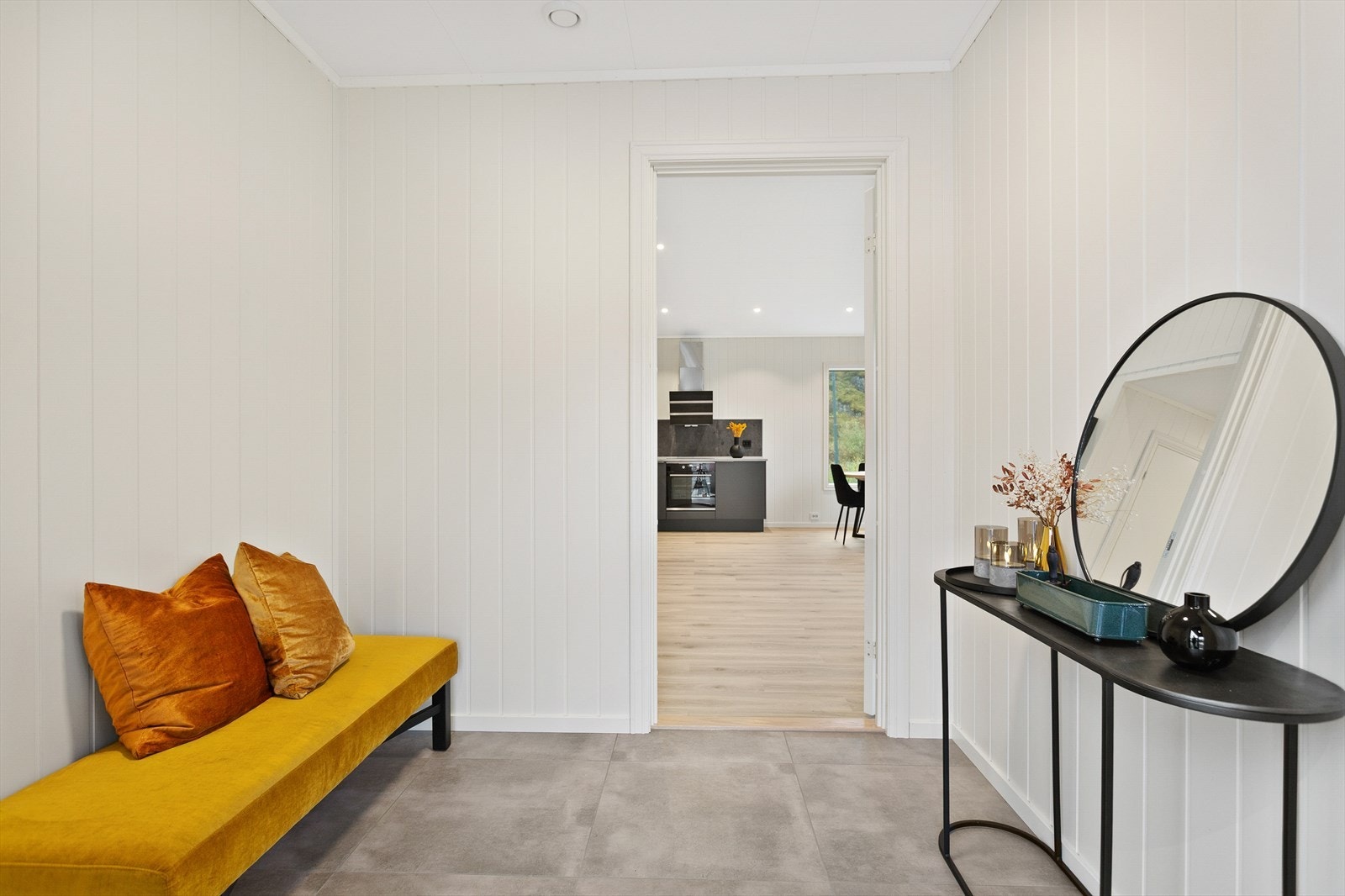 Entréen har flislagt gulv og lys panel på veggene, med direkte tilgang til kjøkkenet. Galleribilde