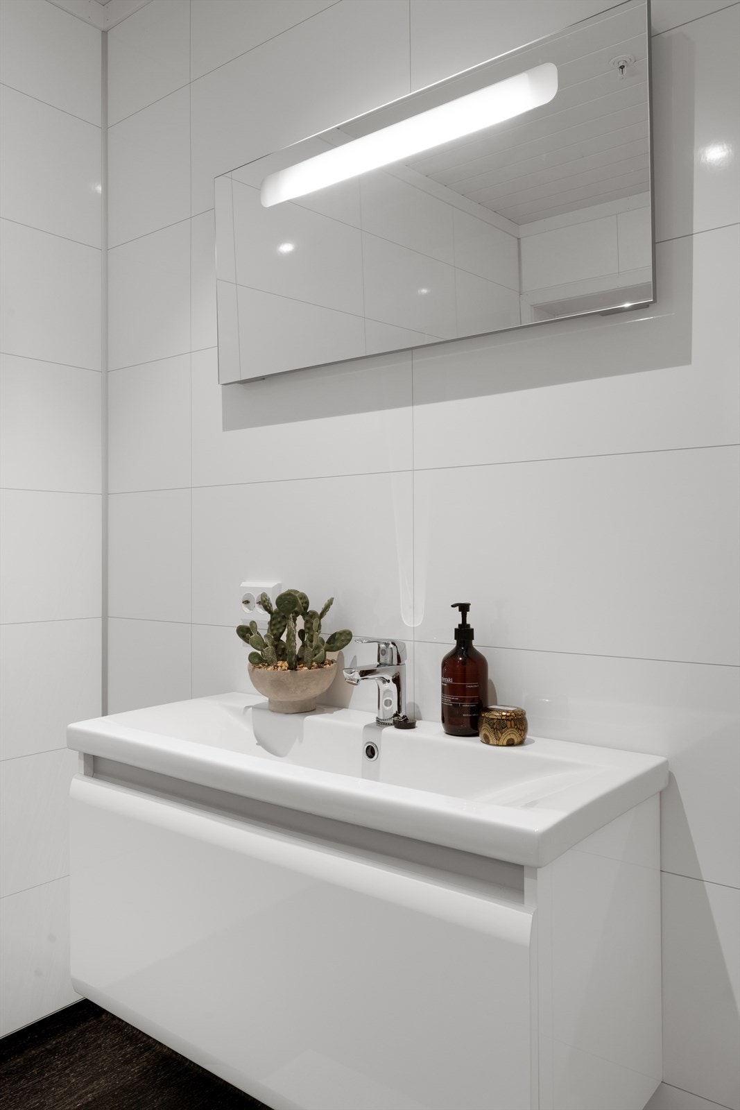 Tidsriktig innredning med heldekkende servant og speil med integrert belysning gir badet et moderne uttrykk. Galleribilde