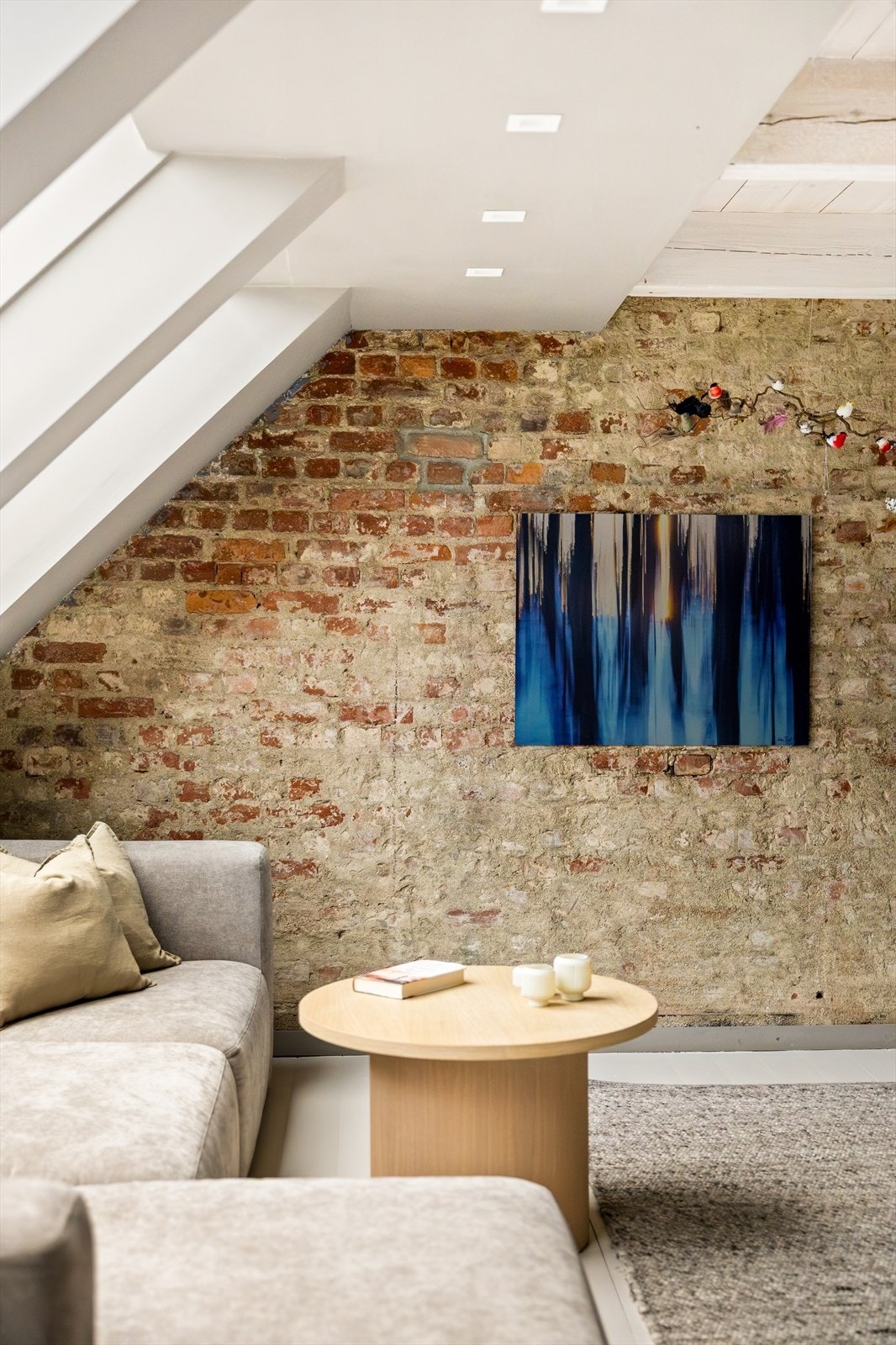 Den vakre teglsteinsveggen gir rommet karakter og en rustikk eleganse som skaper en unik atmosfære. Galleribilde