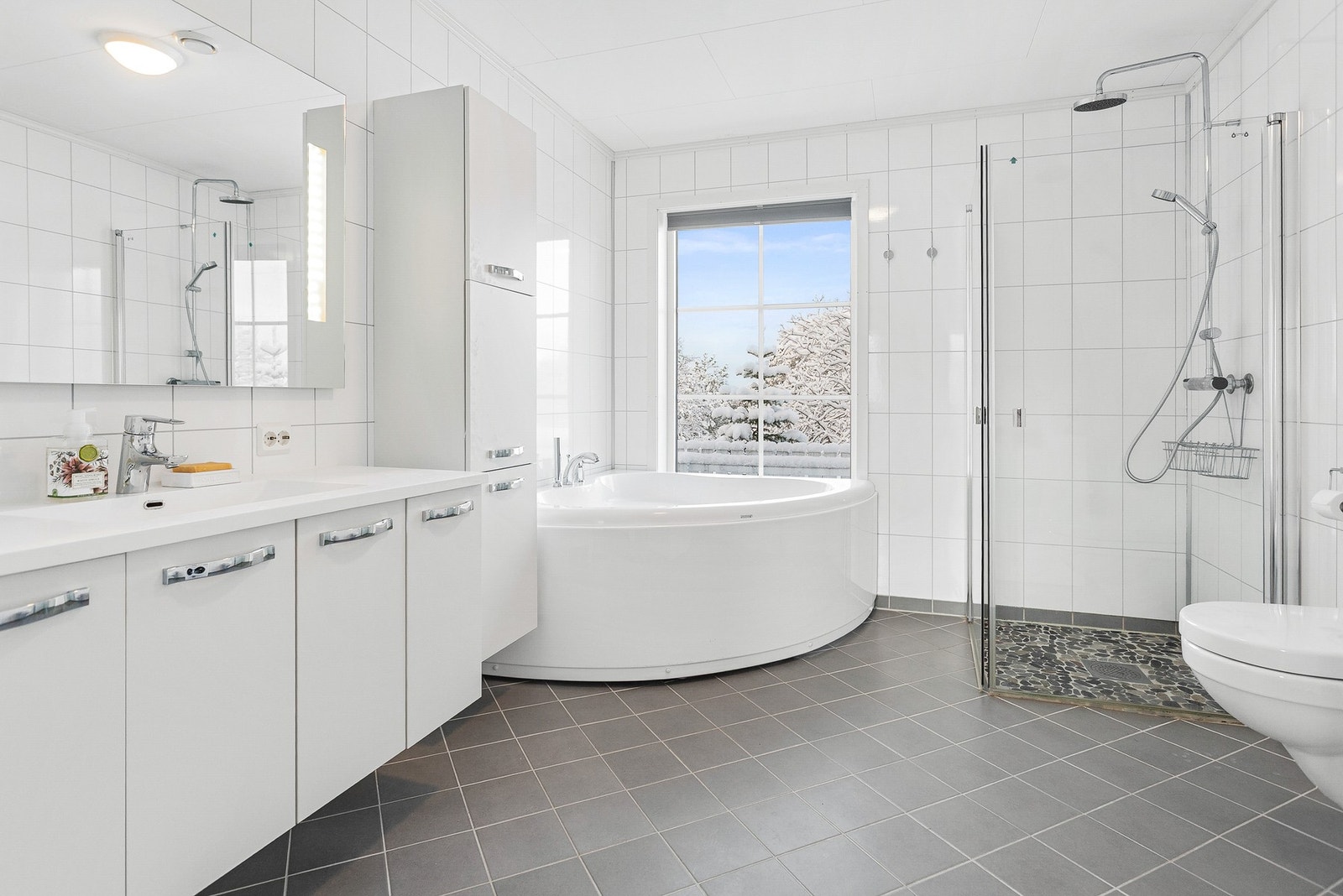 Bad - 9 kvm. Flislagt gulv med varme. Utstyrt med hjørnebadekar, dusjdører, toalett og servantskap Galleribilde