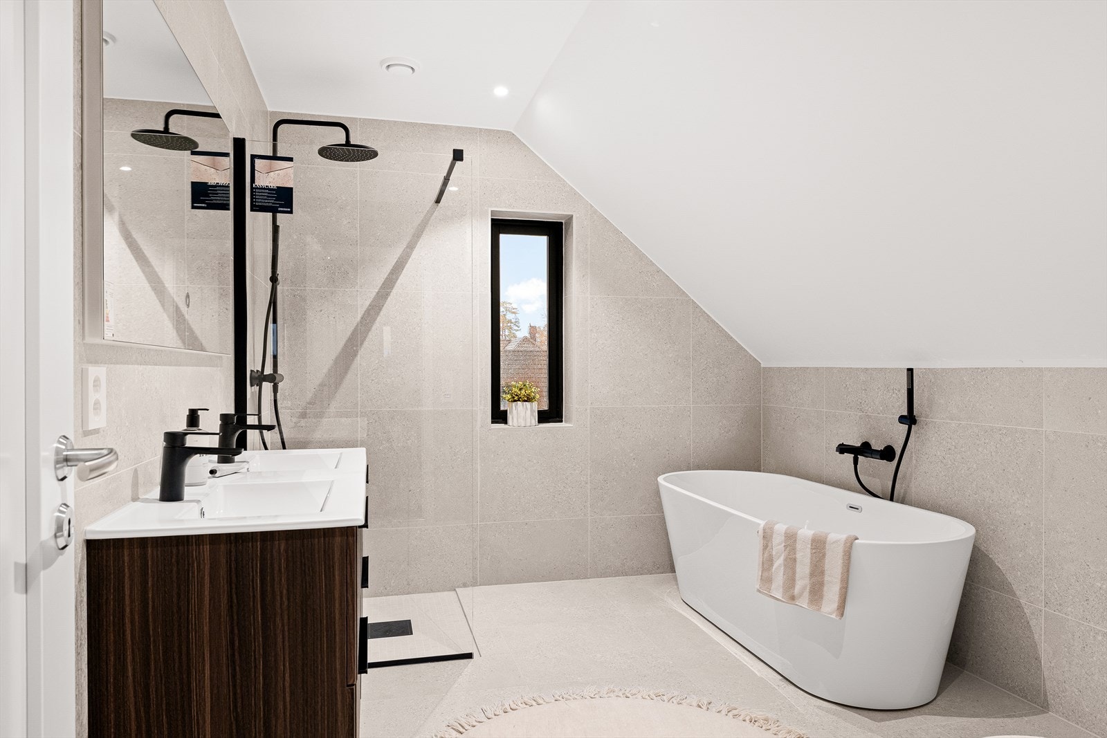 Moderne bad i 2.etasje med delikate fliser og gjennomført fargepalett, som skaper en rolig atmosfære Badet inneholder badekar, innredning med 2 servanter, dusjhjørne og veggmontert toalett. Galleribilde