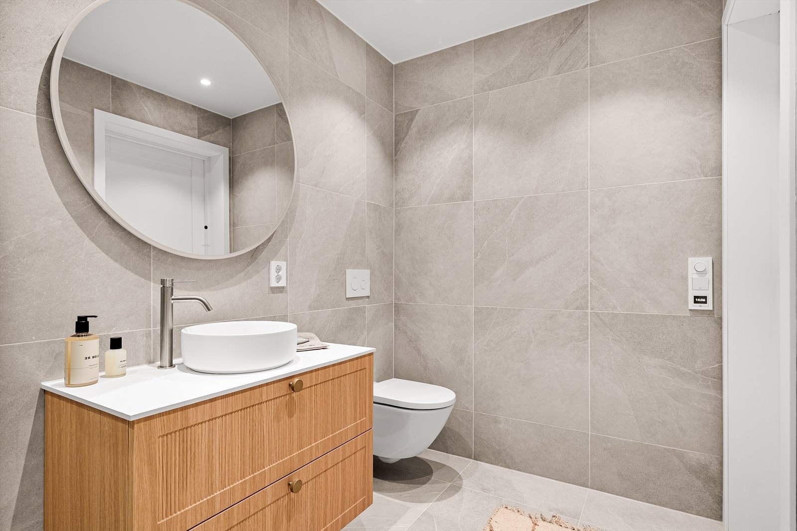 Badet i 1. etasje inneholder innredning med servant, dusjhjørne og veggmontert toalett. Galleribilde