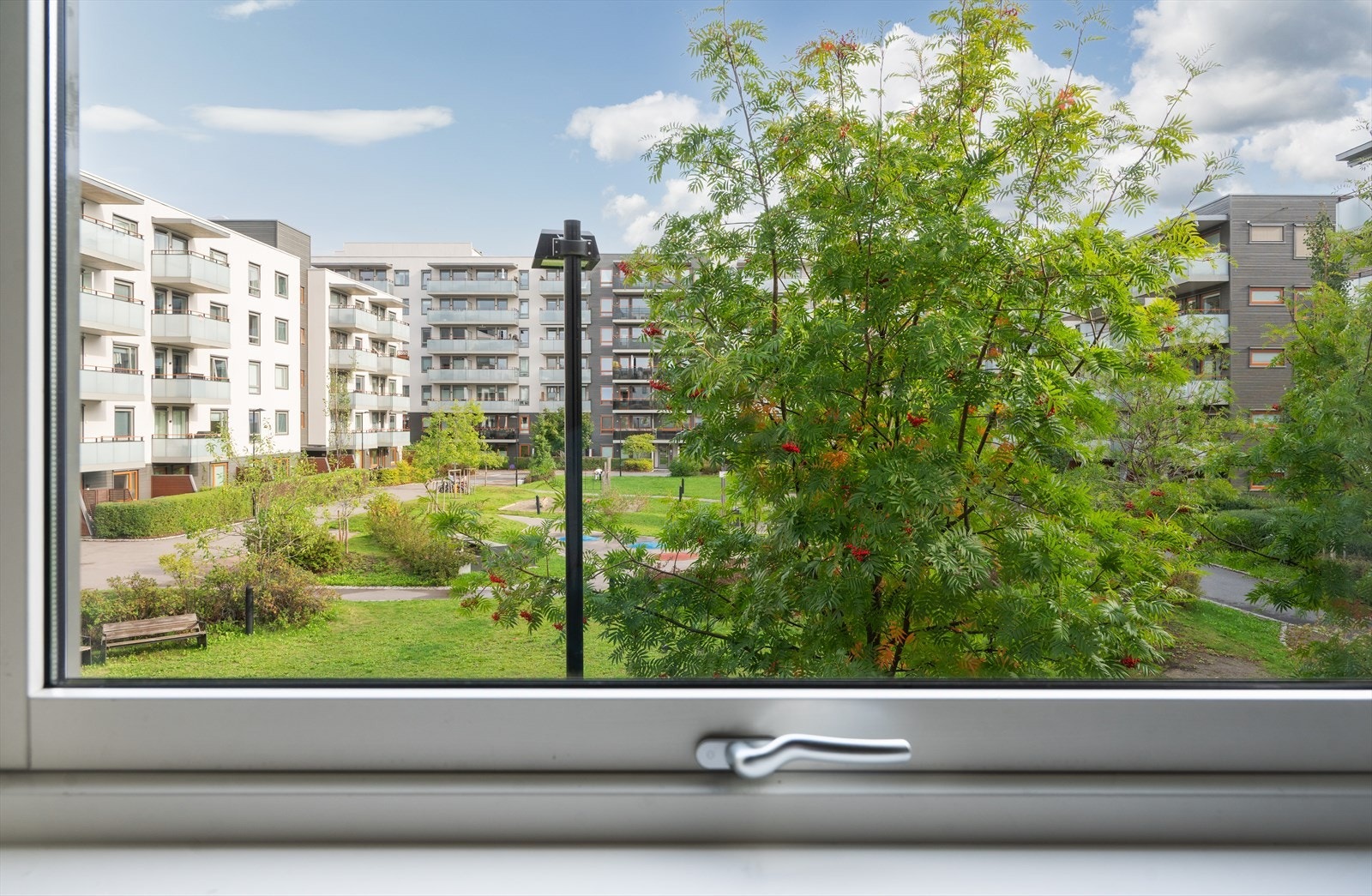 Vindu over kjøkkenbenken kan by på fin utsikt mot grønne uteområder Galleribilde