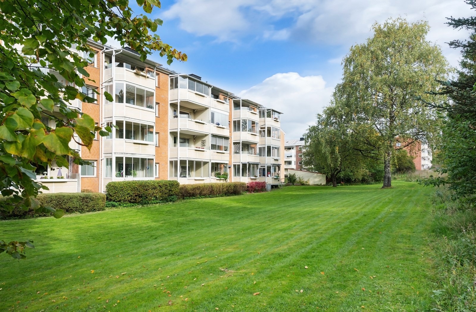 Bygget er omgitt av store, velholdte grøntområder som er tilgjengelige for beboerne. Galleribilde