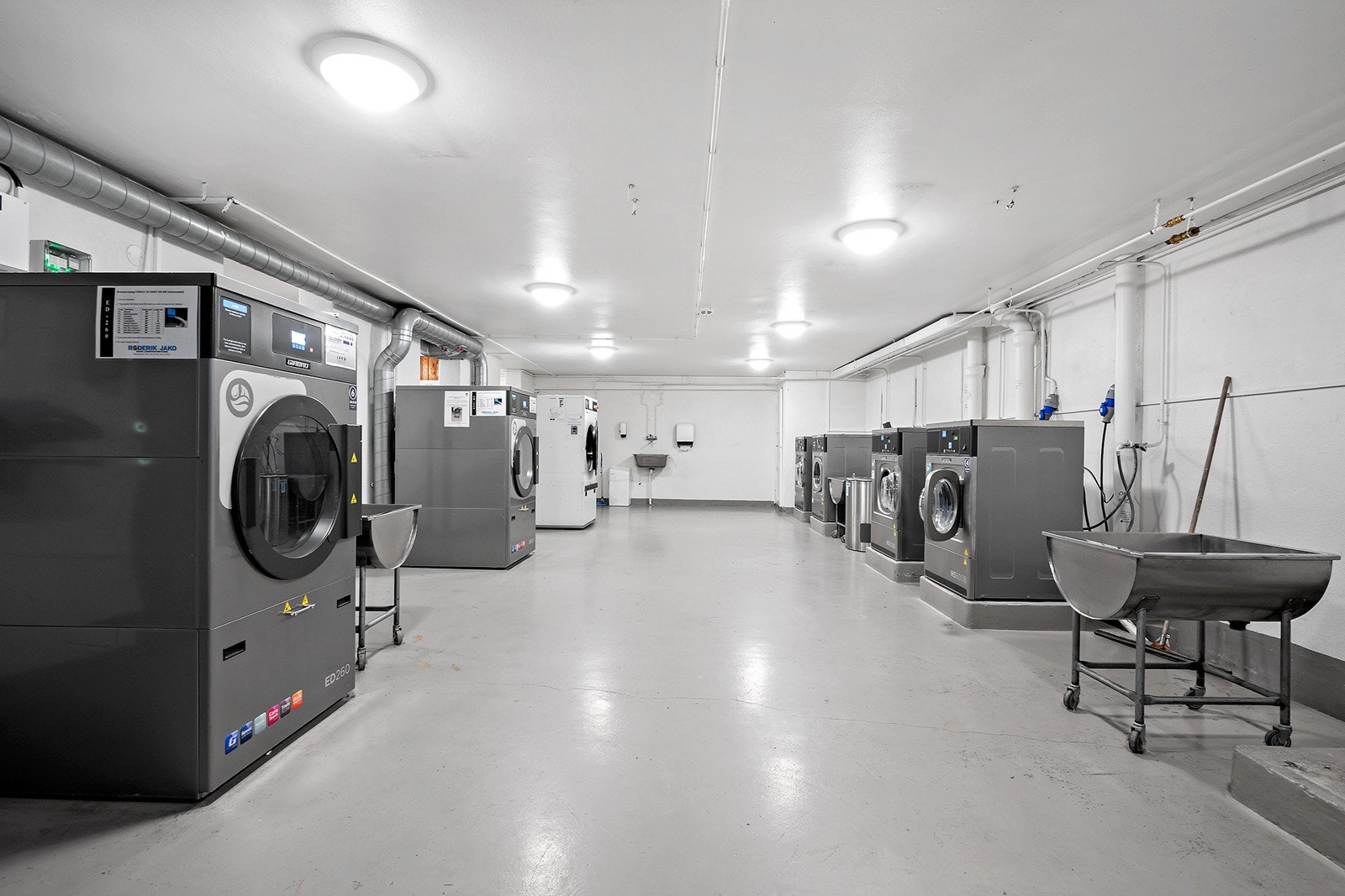 Praktisk fellesvaskeri med store industrimaskiner. Galleribilde