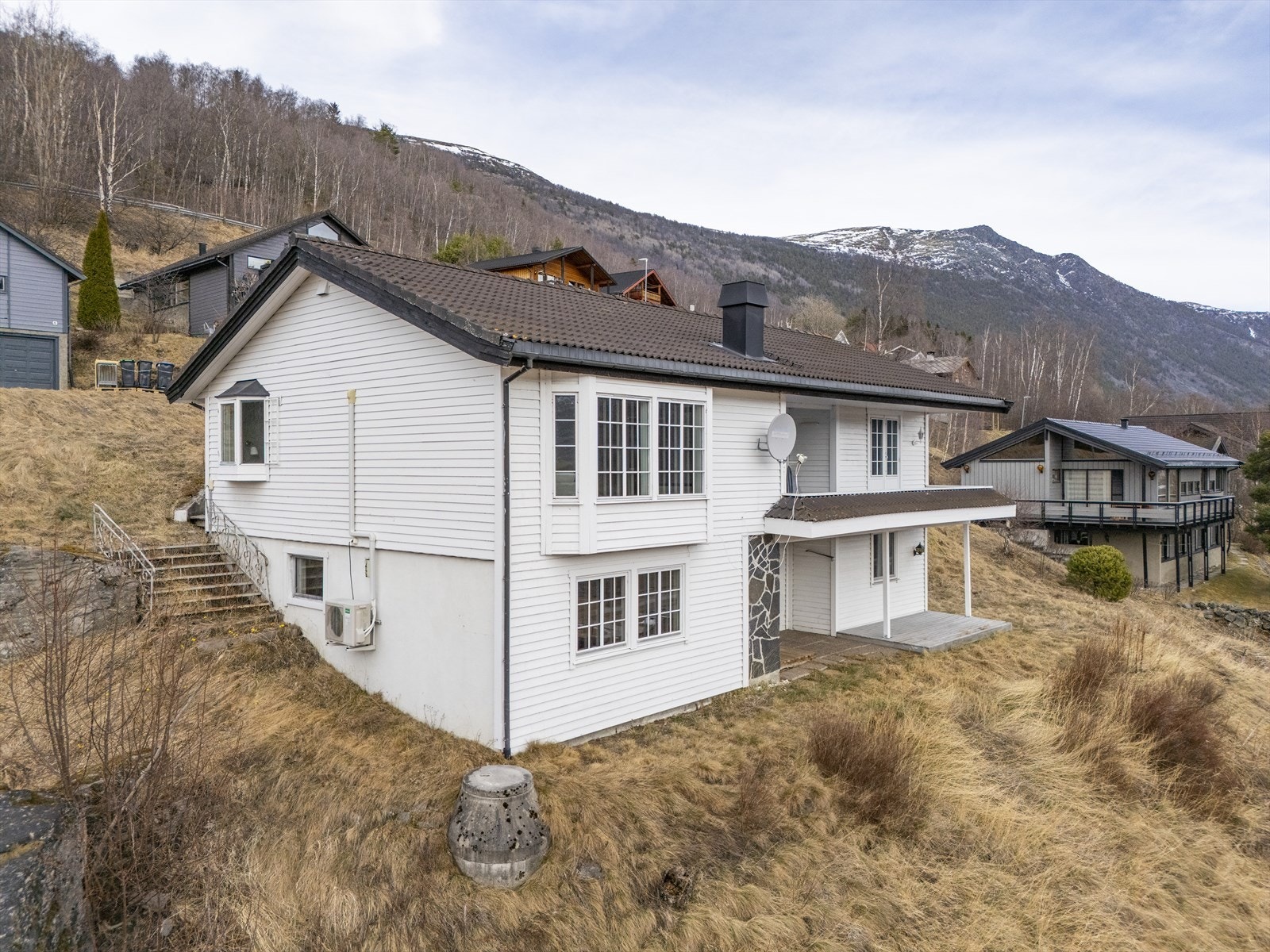 Tomten er opparbeidet med støttemur, grøntarealer og hekkeplanter. Galleribilde