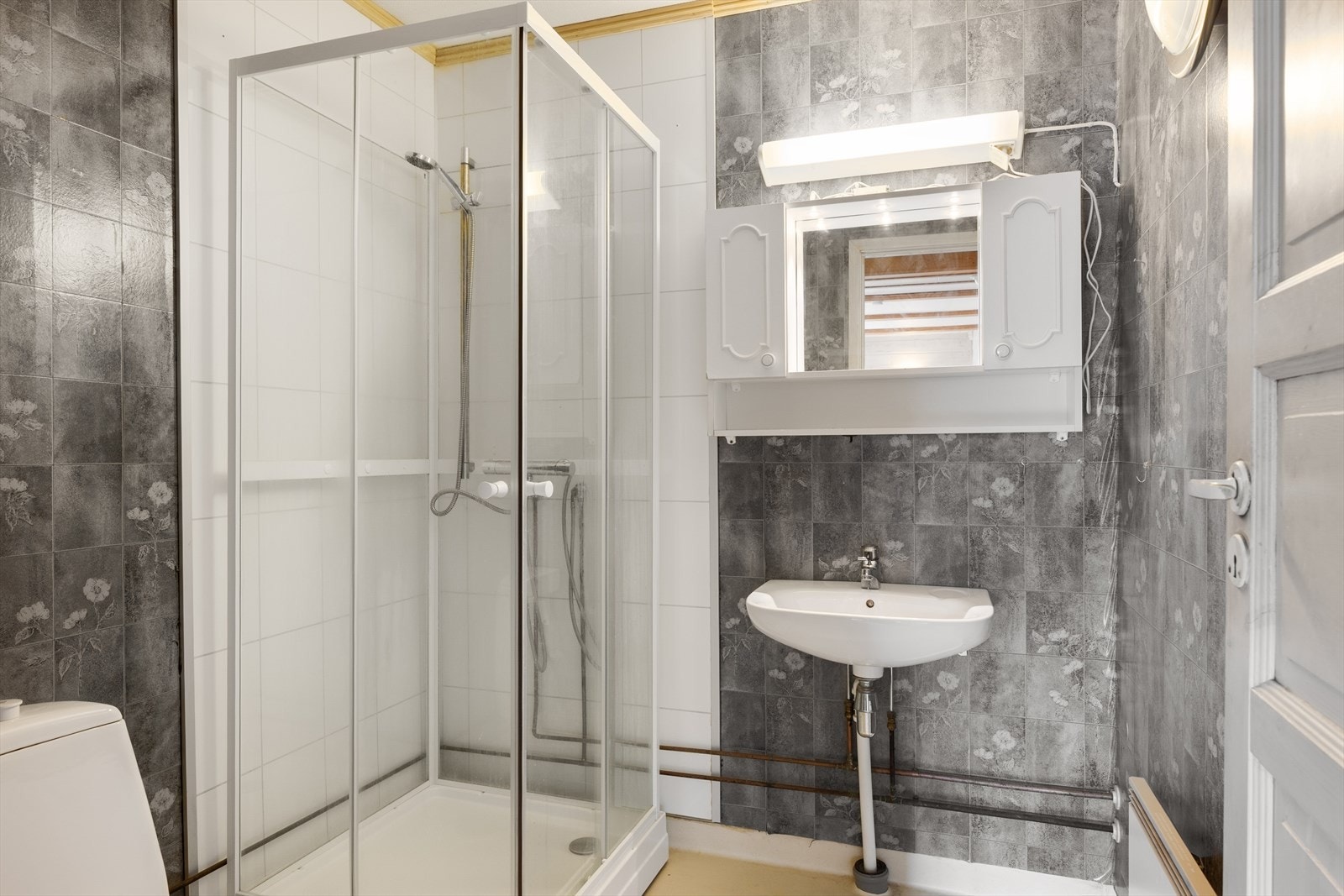 Bad 3 i utleiedelen har tapet på vegg og gulvbelegg, og er innredet m/servant og overskap, dusjkabinett samt gulvmontert wc. Galleribilde