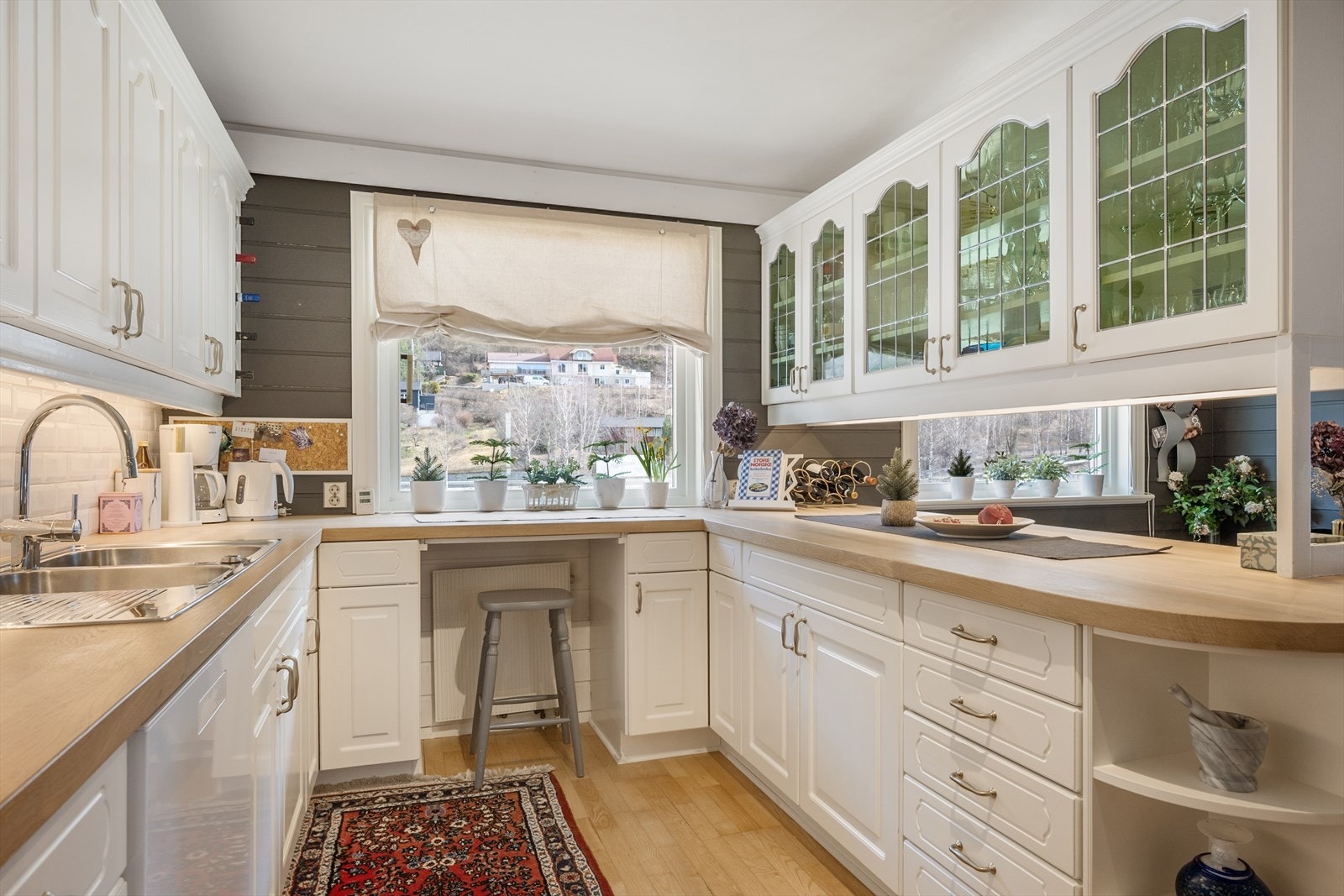 Den lyse innredningen har profilerte fronter og benkeplate i heltre. Noen overskap har glassfront m/farget glass. Galleribilde