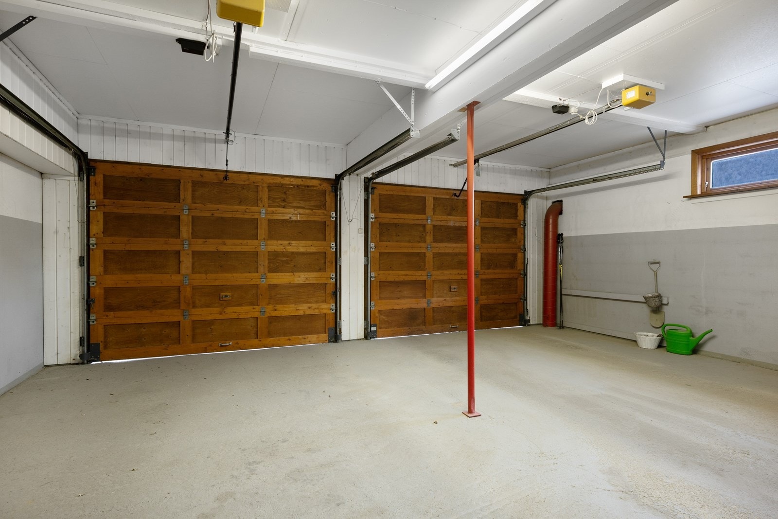 Den integrerte garasjen har porter av tre og plass til to biler. Galleribilde