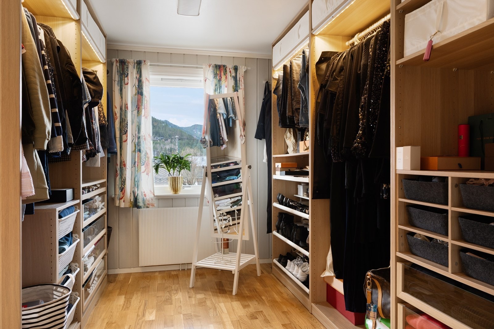 Walk-in garderoben har eikefarget innredning m/hylle- og skuffeplass. Galleribilde