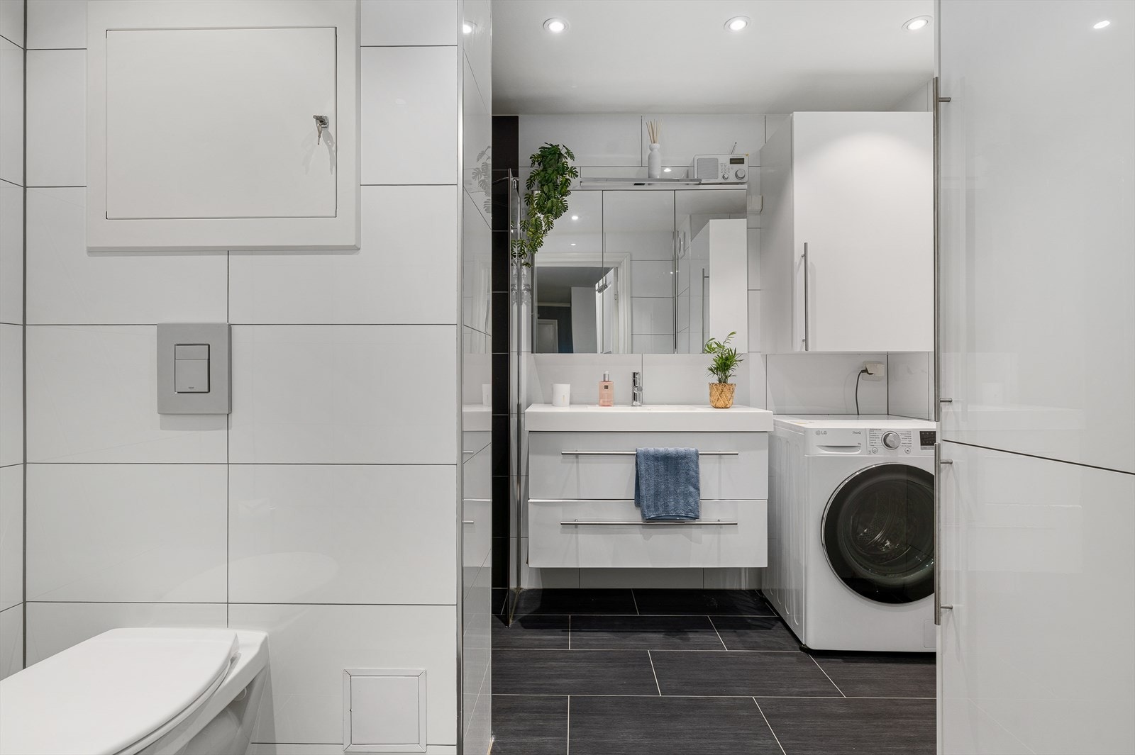 Rommet er innredet med dusjnisje, vegghengt toalett, servant med innredning og opplegg for vaskemaskin - alt du trenger for en praktisk og komfortabel hverdag. Her får du et bad som kombinerer funksjonalitet med moderne design. Galleribilde