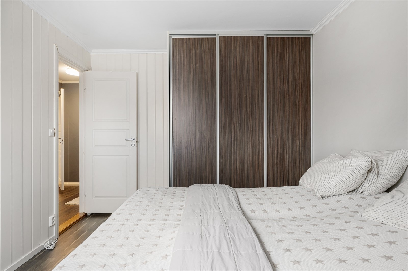 Hovedsoverommet er utstyrt med en romslig skyvedørsgarderobe som gir effektiv og plassbesparende oppbevaring. De glatte dørene gir et moderne uttrykk og bidrar til et ryddig og harmonisk rom. Her får du god plass til klær, sko og tilbehør. Galleribilde