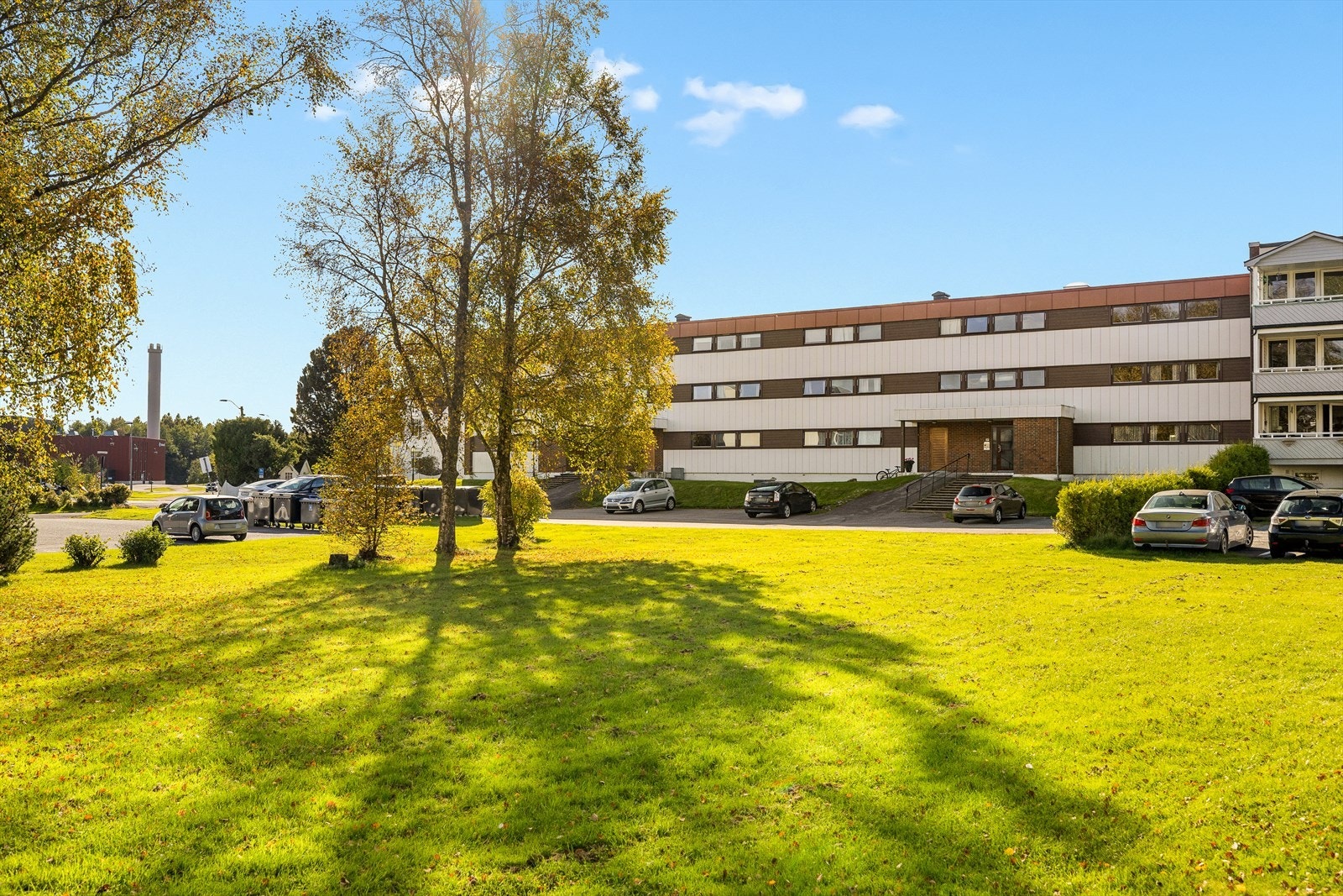 Den østvendte fasaden gir et pent og harmonisk uttrykk, med god morgen- og formiddagssol. Her får du et ryddig og velstelt inntrykk av bygget, med grønne omgivelser og enkel adkomst. Galleribilde