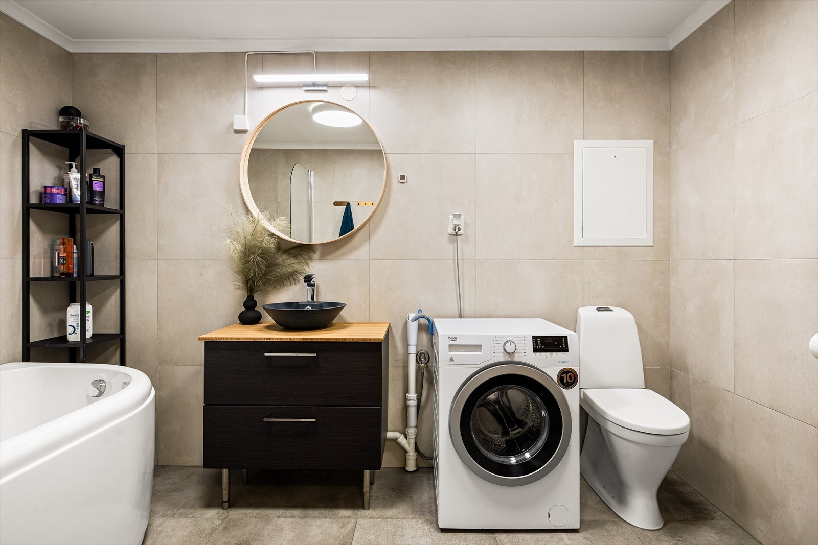 Gulvvarme. Rommet er innredet med badekar, møbel med toppservant, speil, høyskap, klosett og opplegg til vaskemaskin Galleribilde