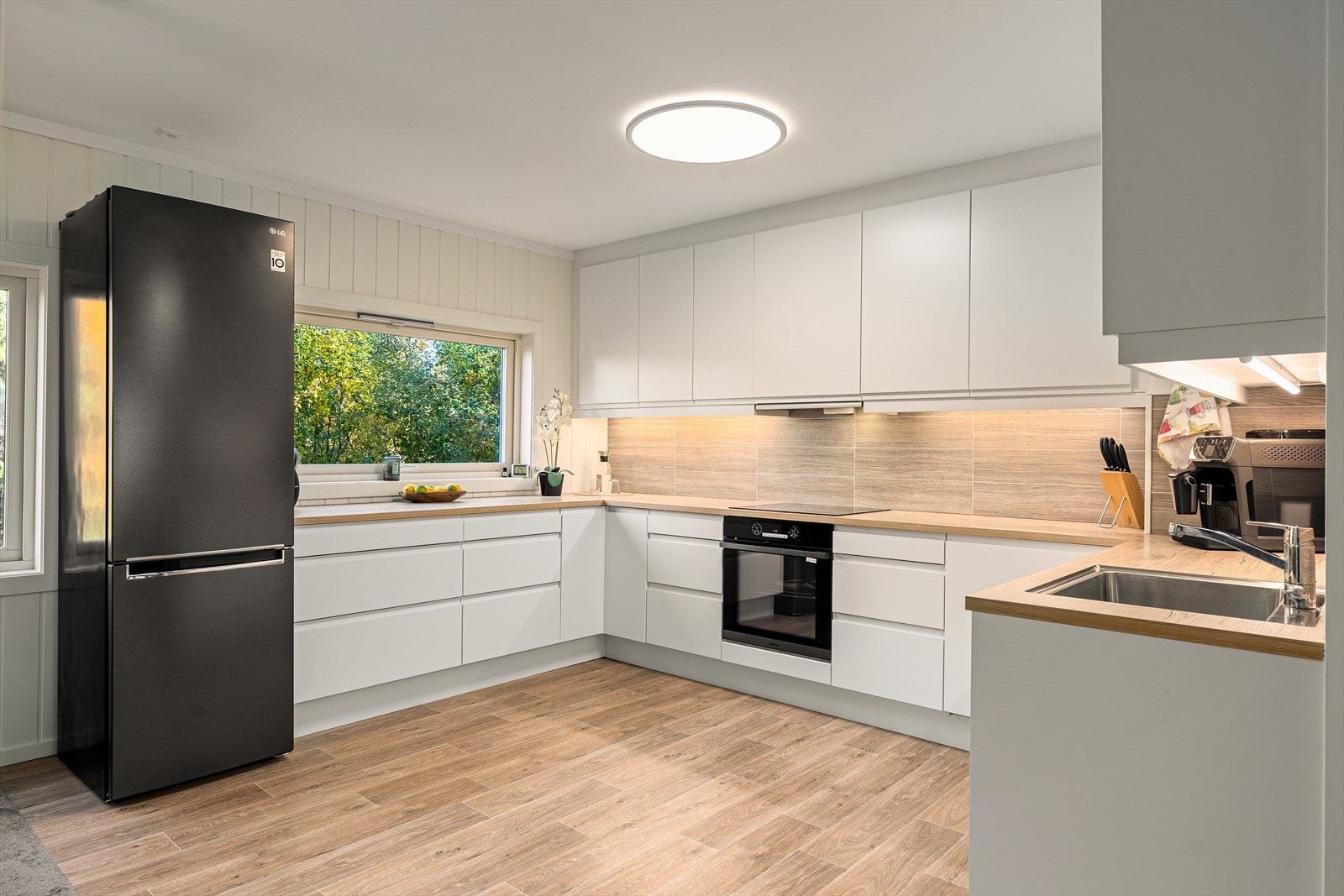 Solid kjøkkeninnredning og godt med både skap og benkplass Galleribilde