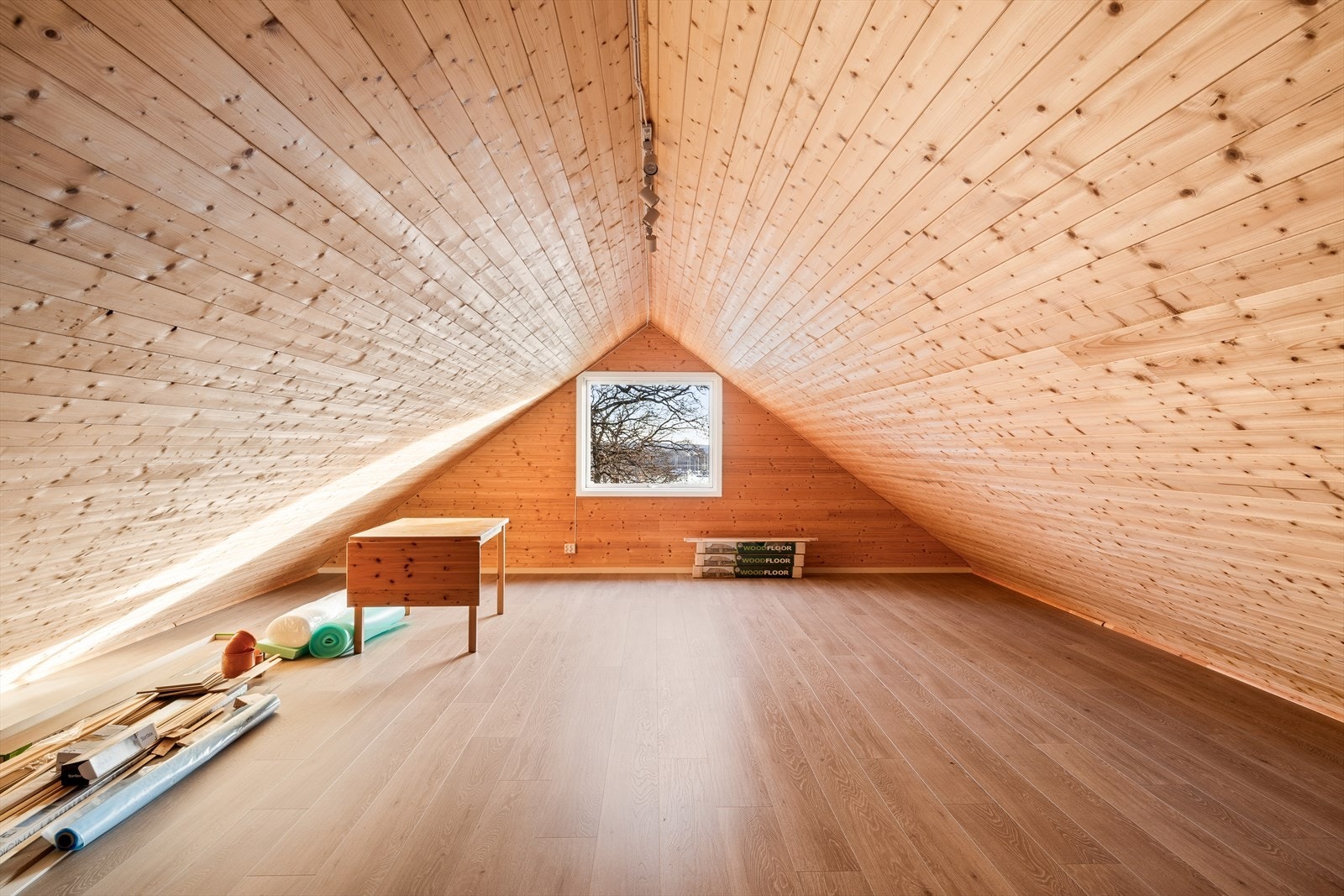 Stort isolert lagringsloft med laminat på gulv og panel på vegg og i himlinger Galleribilde