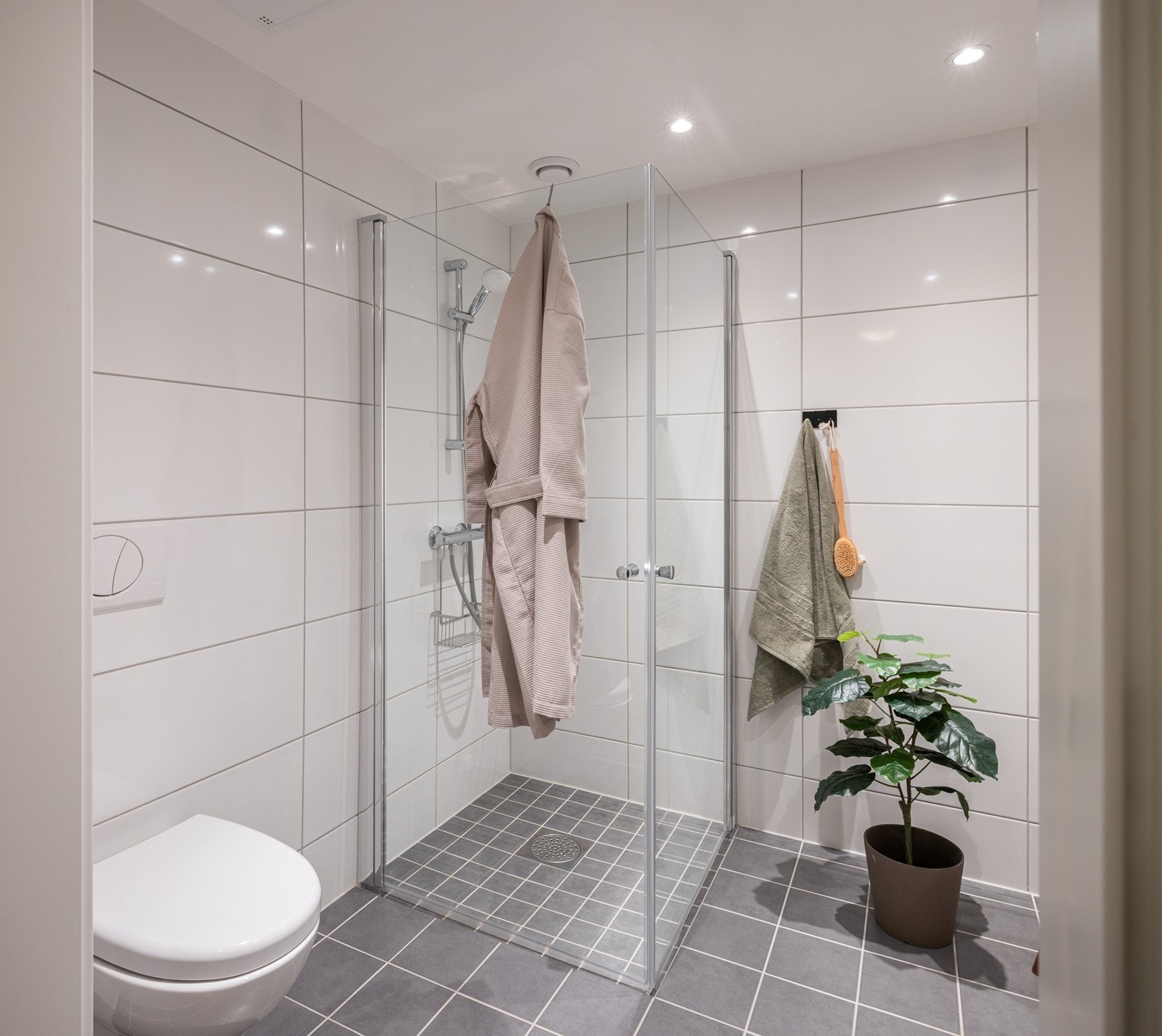 Badet har varme i gulvet og en romslig dusj med glassvegger. Praktiske detaljer gjør morgenrutinene både enkle og behagelige. Galleribilde