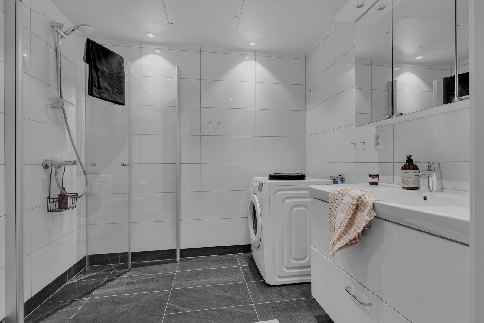 Flislagt og stilfult bad med dushjørne, opplegg til vaskemaskin, servant med over/underskap. Galleribilde