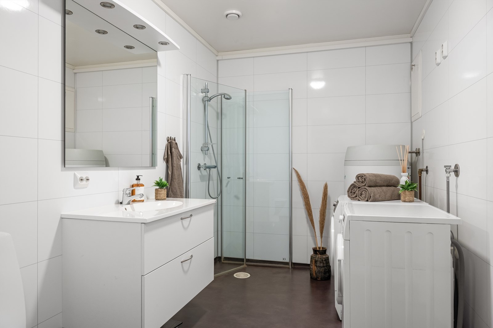 Badet er innredet med servant i baderomsmøbel, toalett og dusjhjørne. Galleribilde