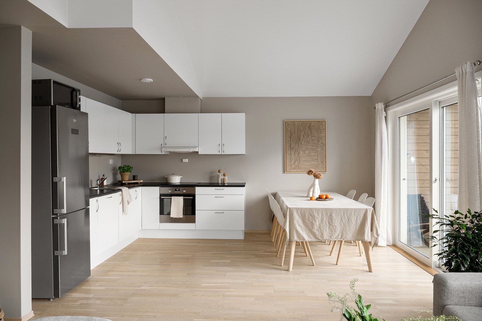 Kjøkkenet har tidløs utførelse med hvite fronter og benkeplate av laminat. Galleribilde