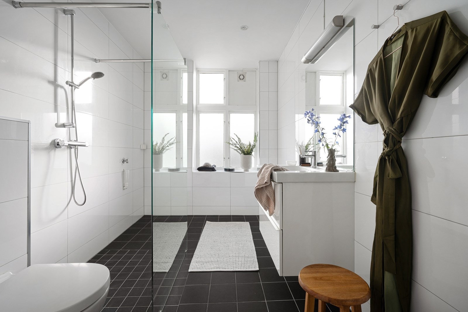 Badet er innredet med toalett, dusjhjørne og servant på underliggende servantskap. Galleribilde