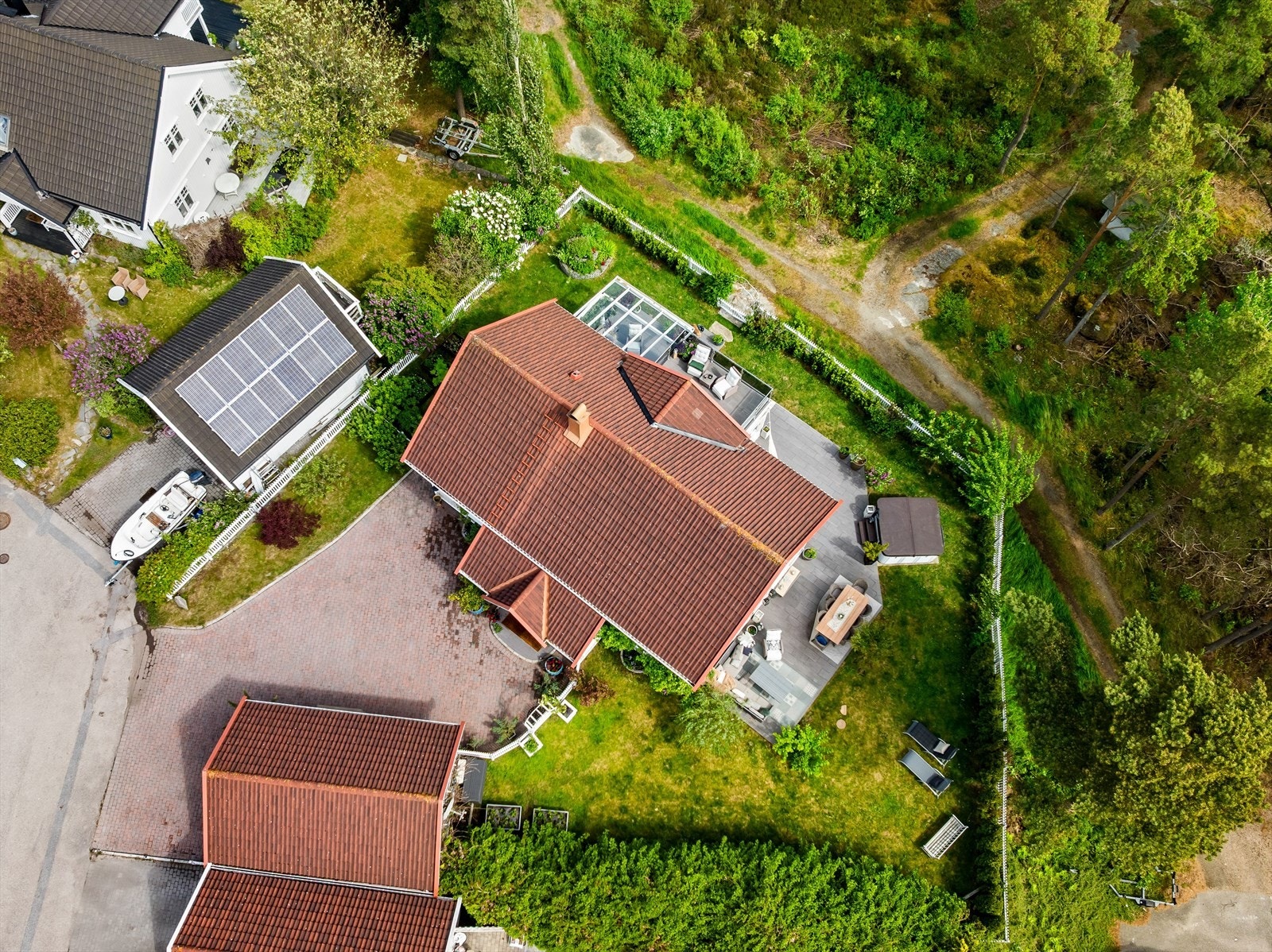 Tomten er tilnærmet flat med en lett helning enkelte steder, og er pent opparbeidet med grøntarealer bestående av gressplen, prydbusker, hekk og variert beplantning. Galleribilde
