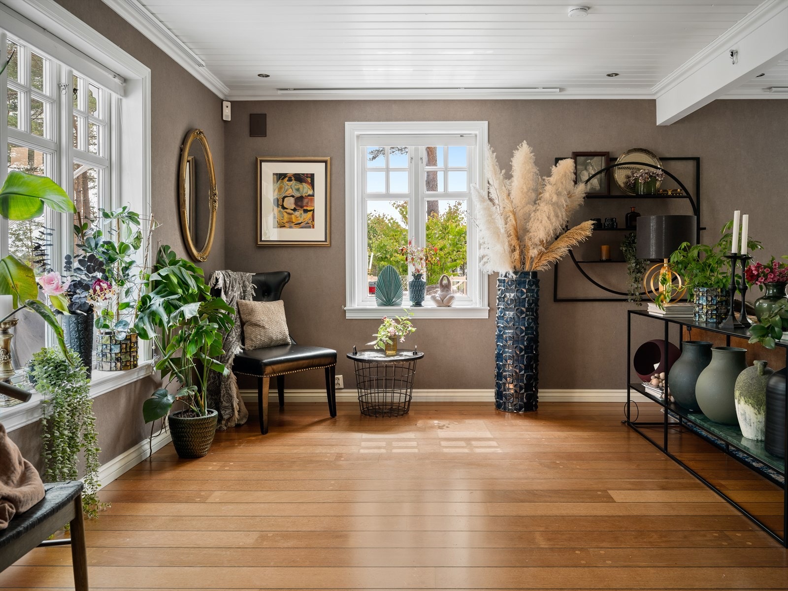 Stuen er romslig og innbydende med god plass til flere ulike soner. I dag deles stuen av med en praktisk og dekorativt konsollbord. Galleribilde